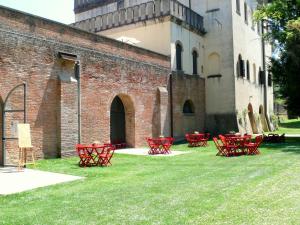 a group of red tables and chairs in front of a building at Wonderful castle just 25 km from Padua in Monselice