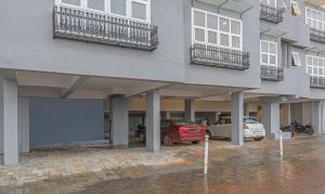 a building with cars parked in a parking lot at Treebo Trend Windsor Heights in Ooty