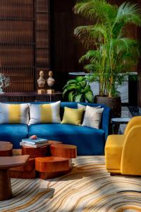 安朱納的住宿－The Westin Goa, Anjuna，客厅配有蓝色的沙发和桌子