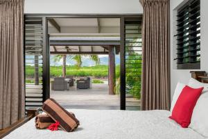 um quarto com uma cama e um pátio em Naisoso Island Villas - Fiji em Nadi