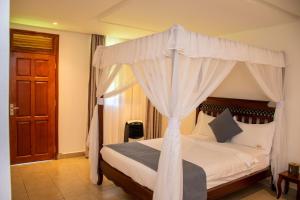 a bedroom with a bed with a canopy at Harry's Kisumu Oasis in Kisumu