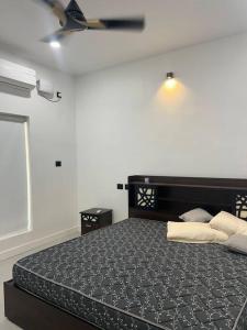 1 dormitorio con 1 cama y ventilador de techo en Tropical oasis en Thiruvananthapuram