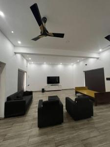 Il comprend un salon avec des canapés et une télévision à écran plat. dans l'établissement Tropical oasis, à Trivandrum
