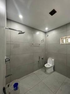 La salle de bains est pourvue d'une douche et de toilettes. dans l'établissement Tropical oasis, à Trivandrum