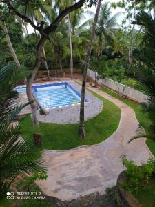 a swimming pool in the middle of a yard with trees at Priyanka Villa in Bentota