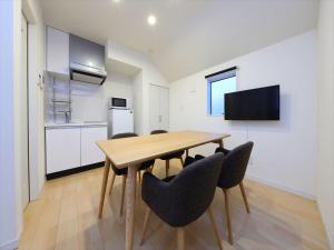 東京的住宿－東京古都澀谷7公寓，厨房以及带木桌和椅子的用餐室。