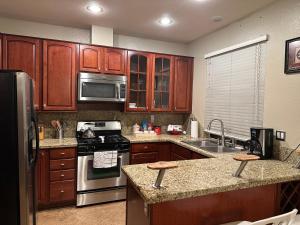 eine Küche mit Holzschränken und Küchengeräten aus Edelstahl in der Unterkunft Charming San Diego Home: For Family or Business! in San Diego