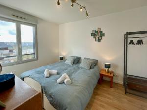 - une chambre avec un lit et 2 serviettes dans l'établissement Le reflet de la Seine - balcon - 2 chambres - RER A, à Carrières-sous-Poissy