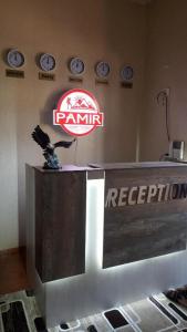 einen Fernseher in einem Zimmer mit Uhren an der Wand in der Unterkunft Pamir Hotel-Hostel in Duschanbe
