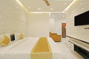 a bedroom with a large bed and a flat screen tv at HOTEL MGM RESIDENCY in New Delhi