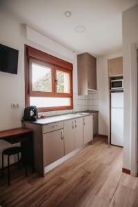 una cocina con armarios blancos y una ventana en Poloestudios, en Zaratán