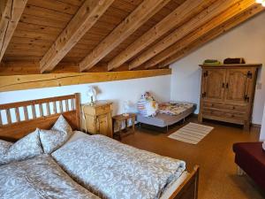 a bedroom with a bed and a chair in a attic at Ferienhaus: idyllisch & erholsam in Eglofs