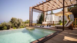 a swimming pool with a pergola and a deck with a chair and umbrella at Lov Faralya Beach & Nature Retreat in Faralya