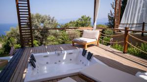 法拉雅的住宿－Lov Faralya Beach & Nature Retreat，浴缸位于木甲板上,配有椅子