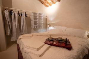 a white bed with a tray of food on it at I COCCI DEL CASTELLO CASAVACANZE in Civitanova Alta