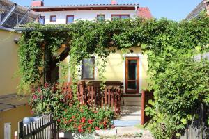 a yellow house with an ivy covered entry way at Penzion Gomelská in Horní Stropnice