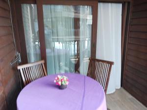 a purple table with a vase of flowers on it at Villa Dalam Laut 580 in Pantai Cenang