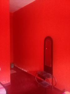 Habitación roja con banco y pared roja en Sayonara Resort en Hambantota