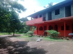 a red building with a red roof at Sayonara Resort in Hambantota