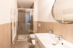 ein Badezimmer mit einem Waschbecken, einem WC und einem Spiegel in der Unterkunft AFFITTACAMERE I BIMBI in Livorno