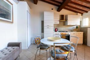 eine Küche mit einem Tisch und Stühlen im Zimmer in der Unterkunft AFFITTACAMERE I BIMBI in Livorno