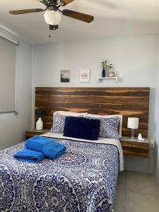 a bedroom with a large bed with blue pillows at Centro Depto 3 Rec 2 baños y Balcon con las mejores vistas a la ciudad AC alberca climatizada parking free in Guadalajara