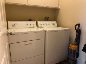 Lavadora y secadora blancas en una habitación pequeña en Charming San Diego Home: For Family or Business!, en San Diego