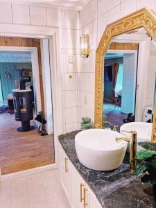 ein Bad mit einem Waschbecken und einem Spiegel in der Unterkunft Smie på sjarmerende og historisk gård 