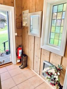 Habitación con paredes de madera, ventana y flores en Smie på sjarmerende og historisk gård 