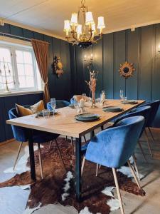 a dining room table with chairs and a large table with a chandelier at Smie på sjarmerende og historisk gård 