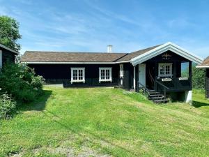 a black house with a grass yard in front of it at Smie på sjarmerende og historisk gård 
