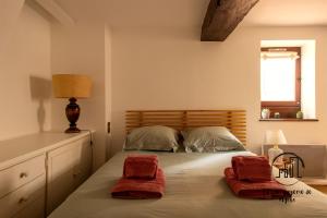 a bedroom with a bed with two red pillows on it at Sous les toits de Sainte-Cécile in Albi