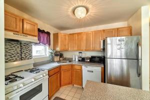 a kitchen with wooden cabinets and a stainless steel refrigerator at Waterfront Gem, 2 Bedroom HOA Community of Whitestone BRONX Free Parking in Whitestone