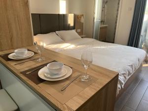 una mesa con dos platos y vasos encima de una cama en Arc de Triomphe apartment en Vientián