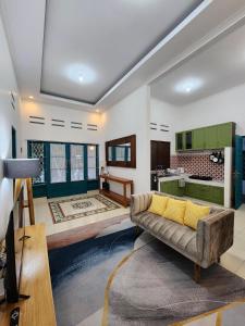 a living room with a couch and a kitchen at OMAH LONDO - 4BR JOGJA CITY in Seturan +30 photos