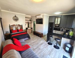 a bedroom with a bed and a couch and a kitchen at De Oude Sleeper Inn 1 Flat in Kimberley