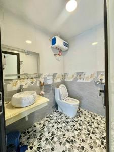 a bathroom with a toilet and a sink at T House - Venuestay in Ba Vì