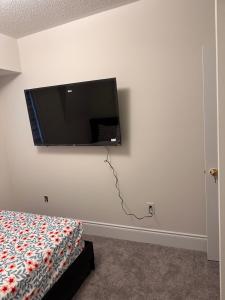 a flat screen tv hanging on a white wall at C&M LUXURY HOME in Brampton