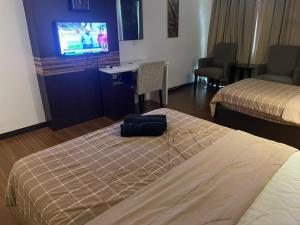 a hotel room with two beds and a flat screen tv at Staycity Apartments - Kota Bharu City Point in Kota Bharu