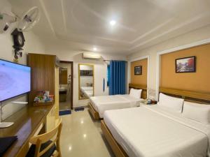 een hotelkamer met 2 bedden en een flatscreen-tv bij A25 Hotel - 13 Bùi Thị Xuân in Ho Chi Minh-stad