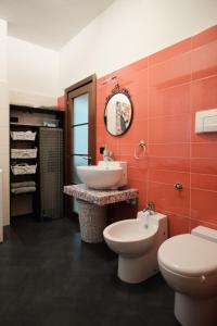 La salle de bains est pourvue de toilettes blanches et d'un lavabo. dans l'établissement La Casa di Zoe, à Locate di Triulzi