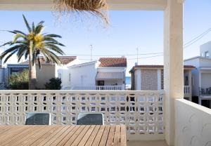 ein Balkon mit einem weißen Zaun und einer Palme in der Unterkunft Apartamento Maria Benlliure in Bellreguart