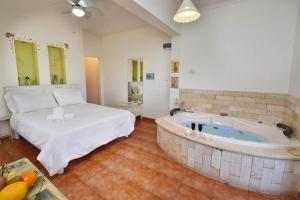 a large room with a large tub in a bedroom at עדנת האוהבים - סוויטות מקסימות ליד הכנרת עם בריכה משותפת in Migdal