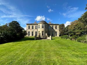 a large house with a large grassy yard at Stunning Historic Suffolk Mansion in Beccles
