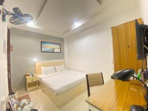 een slaapkamer met een bed, een bureau en een televisie bij A25 Hotel - 13 Bùi Thị Xuân in Ho Chi Minh-stad