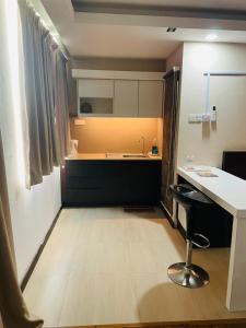 a kitchen with a counter and a table and a stool at Staycity Apartments - Kota Bharu City Point in Kota Bharu