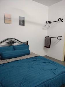 Schlafzimmer mit einem Bett mit blauer Bettwäsche und einer Lampe in der Unterkunft AZK HOMESTAY in Sungai Besar