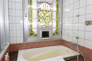 a bath tub in a bathroom with a window at Higashi Kumamoto Business Center in Ozu +46 photos