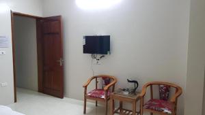 a room with two chairs and a tv on the wall at Love Hotel Hà Đông HN - by BAY LUXURY in Hà Ðông +5 photos