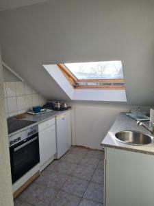 kuchnia ze zlewem i oknem dachowym w obiekcie MM Apartment Wesseling w mieście Wesseling
